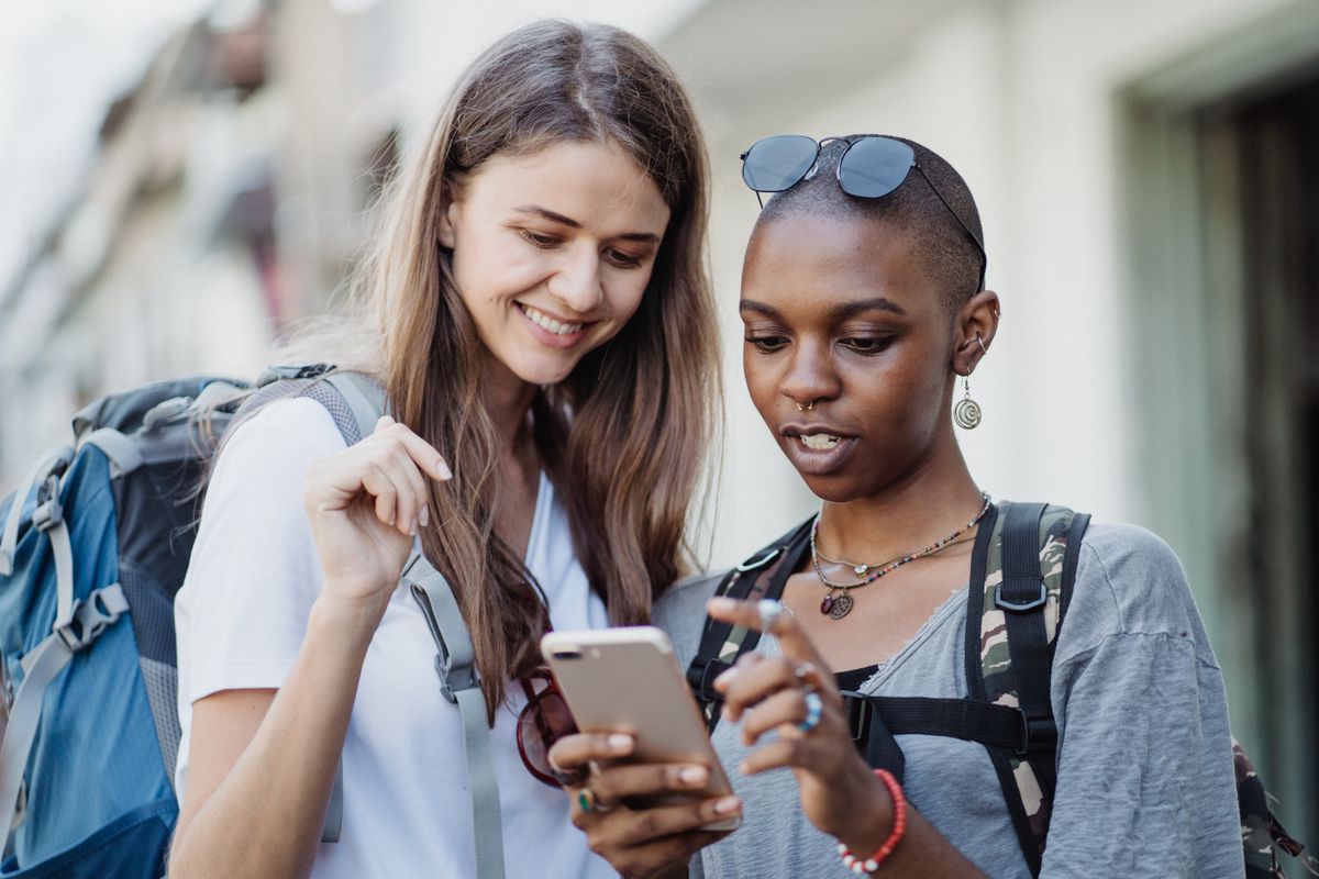 Two travelers booking a trip together on a phone